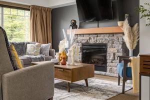 a living room with a couch and a fireplace at Lovely 3BR condo with Hot Tub at the Edge of Canmore in Dead Man's Flats