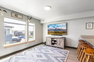 a living room with a tv and a window at Lorene St Condo in Rexburg +4 photos