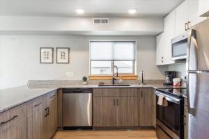 a kitchen with wooden cabinets and a large window at Lorene St Condo in Rexburg
