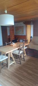 a wooden table and chairs in a room with a bed at Ap1 Eyne 2600 Estación de Ski in Eyne +8 photos