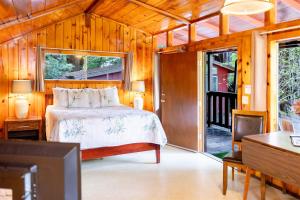 - une chambre avec un lit dans une maison en bois dans l'établissement Fern River Resort, à Felton