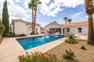 メスキートにあるDesert Dream Retreat-Golf And Pool Paradiseのヤシの木が茂る家の前のスイミングプール