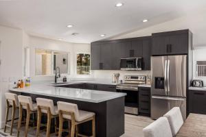 メスキートにあるDesert Dream Retreat-Golf And Pool Paradiseのキッチン(バースツール付きの広いキッチンアイランド付)
