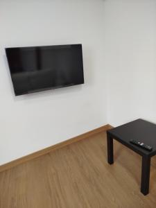 sala de estar con mesa y TV de pantalla plana en La de Simón, en A Guarda
