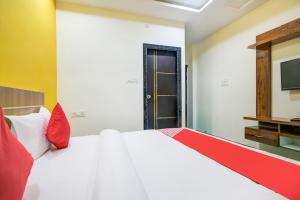 a bedroom with a white bed and a television at Hotel O The Rudransh Inn in Indore +29 photos