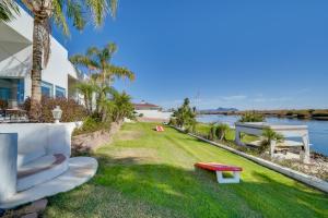 a grassy yard with a white couch and a view of the water at Magnificent Big River Home with Beautiful Views in Parker
