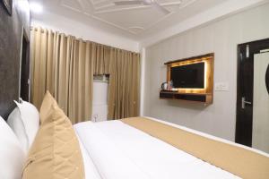 a hotel room with a bed and a television at Hotel Luck Recdancy mahipalpur in New Delhi