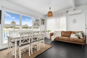 een woonkamer met een tafel en een bank bij Whispers of Sunset in Dromana