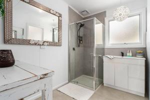 een badkamer met douche, wastafel en spiegel bij Whispers of Sunset in Dromana +12 foto's