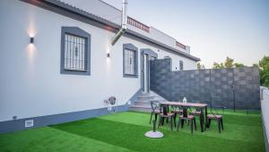 eine Terrasse mit einem Tisch und Stühlen auf einem Rasen in der Unterkunft Villas Del Acebuche in Córdoba
