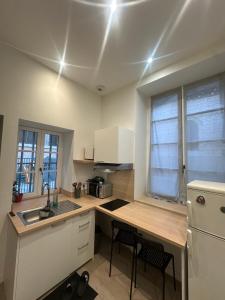 a kitchen with a counter and a sink and a refrigerator at Magnifique appartement neuf Bellecour in Lyon +2 photos