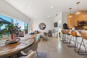 マンハッタン・ビーチにあるOcean View condo in the heart of Manhattan Beachのテーブルと椅子のあるキッチンとリビングルーム