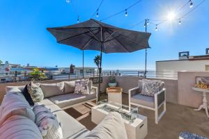 マンハッタン・ビーチにあるOcean View condo in the heart of Manhattan Beachのパティオ(ソファ、屋上のパラソル付)