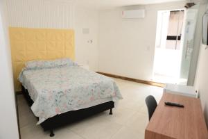 サルバドールにあるPousada gran souzaのベッドと木製のテーブルのある寝室