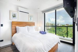 a bedroom with a large bed with a large window at Cozy Playa Escape Pool, Beach & 5th Avenue in Playa del Carmen