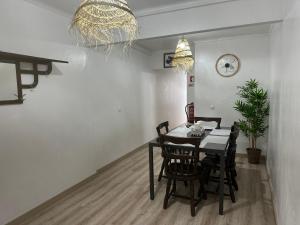 a dining room with a table and chairs and a clock at Casinha Santa Maria in Vila do Porto