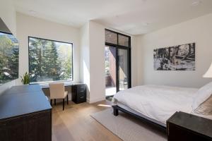 a bedroom with a bed and a desk and windows at The Lofts at 660 #201 in Ketchum