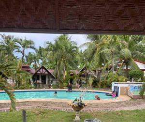 a swimming pool with people in a resort at Skipper Joes Resort in Dauis