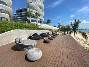 a wooden deck with chairs and umbrellas on a beach at Beautiful 2Bed 2Bath Beach Apt in Cruz de Huanacaxt in Cruz de Huanacaxtle
