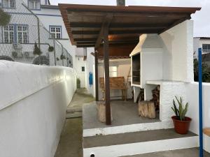 a patio with a wooden cover on the side of a house at Casinha Santa Maria in Vila do Porto