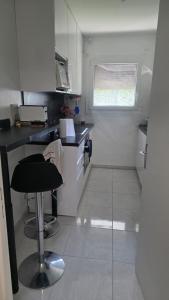 a kitchen with a stool in the middle of a kitchen at chambre - Paris - salons & missions pro in Montrouge