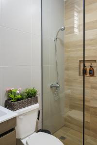 La salle de bains est pourvue d'une douche et de toilettes avec des plantes. dans l'établissement Acogedor Apartamento en Punta Cana, a solo 8 minutos del Aeropuerto y las hermosas Playas, à Punta Cana