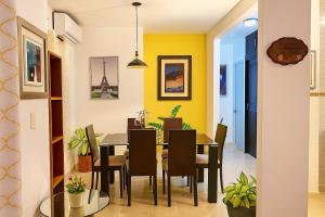 une salle à manger avec des murs jaunes, une table et des chaises dans l'établissement Acogedor Apartamento en Punta Cana, a solo 8 minutos del Aeropuerto y las hermosas Playas, à Punta Cana 6 autres photos