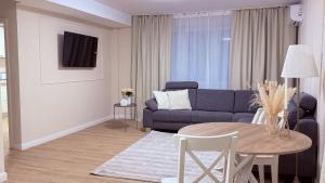 een woonkamer met een blauwe bank en een tafel bij Apartments am Schwarzen Berge in Garbsen