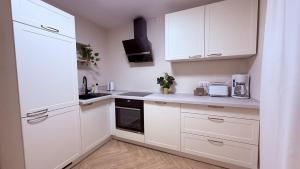 een witte keuken met witte kasten en apparaten bij Apartments am Schwarzen Berge in Garbsen