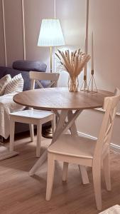 een witte eettafel en stoelen met een lamp bij Apartments am Schwarzen Berge in Garbsen