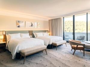 a hotel room with two beds and a balcony at voco Gosford by IHG in Gosford