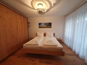a bedroom with a large bed with white sheets at Galsterberg in Gröbming