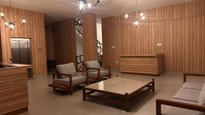 a living room with chairs and a table and a counter at Boulevard Hotel Crateús in Crateús
