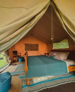 1 dormitorio en una tienda de campaña con 1 cama en Sitinggil muncul Glamping and Villas, en Muncul