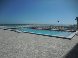 a swimming pool on the beach with the ocean in the background at Beachside Bliss Ocean-View Condo with Pool and Private Beach Access Perfect for Families and Couples in Daytona Beach