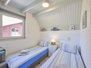 a small room with two beds and a window at De Zeediek in Herkingen