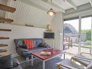 a living room with a couch and a table at De Zeediek in Herkingen
