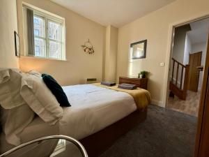 a bedroom with a large white bed with a window at Modern 2BR Flat in Bradford City Centre! in Bradford