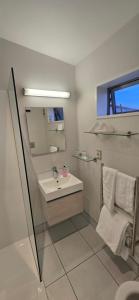 Carters by the Sea في Carters Beach: حمام مع حوض ومرآة