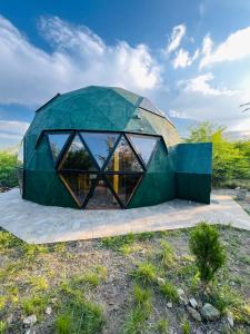 a house with a green roof and glass walls at Domo Del Rio in Los Reartes +29 photos