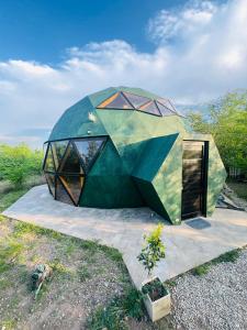a dome shaped house with a green at Domo Del Rio in Los Reartes
