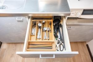 a drawer filled with utensils under a kitchen counter at oyadoya gifu kano 岐阜駅徒歩12分 名古屋駅35分 大人数貸切 最大8名 駐車場有り in Gifu