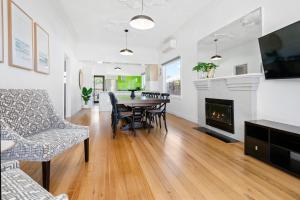 a living room with a table and a fireplace at Shoreline in Tootgarook +28 photos