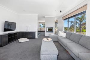 a living room with a gray couch and a tv at Shoreline in Tootgarook
