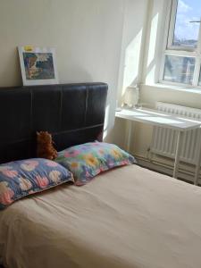 Una cama con cabecero negro y una almohada. en Fulham Palace Residence, en Londres