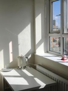 una lámpara sentada en una mesa frente a una ventana en Fulham Palace Residence, en Londres