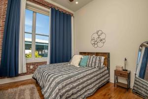 ein Schlafzimmer mit einem Bett mit blauen Vorhängen und einem Fenster in der Unterkunft Cooper Corner -OldCity-SelfCheckIn- in Knoxville