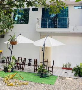 eine Terrasse mit einem Tisch, Stühlen und Sonnenschirmen in der Unterkunft El Gran Pajonal Hotel in Nueva Cajamarca