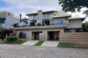 a large white building with a sign in front of it at Residencial Flamboyant in Garopaba