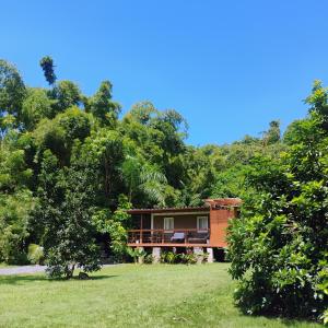 a house in the middle of a field with trees at Zen Den Nature Retreat on a River in Rincon